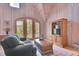Relaxing living room features wood walls, comfortable seating, and entertainment center at 4158 Wild Flower Ct, Evergreen, CO 80439