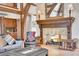 Charming living room with stone fireplace, wooden beams, and comfortable seating arrangements at 4158 Wild Flower Ct, Evergreen, CO 80439