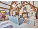 Bright living room featuring vaulted ceilings with wood beams, a stone fireplace, and comfortable seating at 4158 Wild Flower Ct, Evergreen, CO 80439