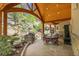 A covered outdoor patio features stone pavers, a built-in grill, and an arched wood beam ceiling at 4158 Wild Flower Ct, Evergreen, CO 80439