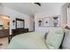 Well-lit bedroom featuring modern art, a dresser, and a glimpse into the en suite bathroom at 12301 Festival Ln, Thornton, CO 80241