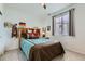 Comfortable bedroom features a wooden headboard, carpeted floors, and a ceiling fan at 12301 Festival Ln, Thornton, CO 80241