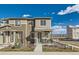 Two-story townhome with modern facade, covered entryway, and landscaped front yard at 12301 Festival Ln, Thornton, CO 80241