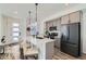 Modern kitchen features stainless steel appliances, gray cabinets, and a stylish island with seating at 12301 Festival Ln, Thornton, CO 80241