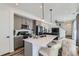 Contemporary kitchen open to the living room is equipped with island seating and stainless appliances at 12301 Festival Ln, Thornton, CO 80241