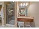 Modern bathroom with a glass-enclosed shower, vanity with seated makeup mirror, and stylish fixtures at 15789 W 95Th Pl, Arvada, CO 80007