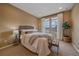 Cozy bedroom with a wicker headboard, neutral tones, and bright windows at 15789 W 95Th Pl, Arvada, CO 80007