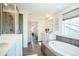 Bathroom with a glass shower and a soaking tub with wood-look tile floors at 9607 Williamsburg St, Littleton, CO 80125