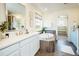 Bright bathroom featuring a soaking tub, double vanity, and wood-look tile floors at 9607 Williamsburg St, Littleton, CO 80125