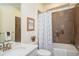 Modern bathroom with a shower-tub combo, decorative tile, and a sleek vanity at 9607 Williamsburg St, Littleton, CO 80125