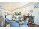 Dining area with a glass table, six chairs, and view to a modern open kitchen at 9607 Williamsburg St, Littleton, CO 80125