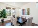 Bright dining room features hardwood floors, large windows, modern decor and seating for six at 9607 Williamsburg St, Littleton, CO 80125