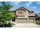 Charming two-story home with a stone and wood facade, a covered front porch, and an attached three-car garage at 9607 Williamsburg St, Littleton, CO 80125