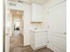 Laundry room with a sink, white cabinetry, and a white door at 9607 Williamsburg St, Littleton, CO 80125