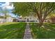 Spacious backyard with lush lawn, mature tree, and shaded patio area, ideal for outdoor activities at 1211 S Zuni St, Denver, CO 80223