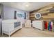 Bedroom featuring light purple walls, a wood accent wall, and a white crib and changing table at 1211 S Zuni St, Denver, CO 80223