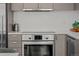 Modern kitchen features stainless steel oven and dishwasher with quartz countertop at 1750 Wewatta St # 605, Denver, CO 80202