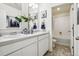 Bright bathroom featuring double sinks with white cabinets, and a view into the shower and toilet at 27756 E Byers Pl, Aurora, CO 80018