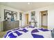 Bright bedroom with large windows, modern art, a gray dresser, and a geometric-patterned bed set at 27756 E Byers Pl, Aurora, CO 80018