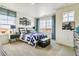 Cozy bedroom with a large window, airplane art, and a blue, white, and black bed set at 27756 E Byers Pl, Aurora, CO 80018