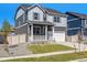 Attractive gray two-story home boasts a charming porch, and well-kept landscaping at 27756 E Byers Pl, Aurora, CO 80018