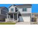 Inviting two-story home with gray siding, a front porch, a two-car garage, and manicured lawn at 27756 E Byers Pl, Aurora, CO 80018