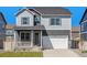 Charming two-story home with gray siding, white trim, a front porch, and a two car garage at 27756 E Byers Pl, Aurora, CO 80018