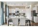 Bright kitchen and dining area featuring white cabinets, stainless steel appliances, and modern decor at 27756 E Byers Pl, Aurora, CO 80018