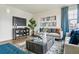 Cozy living room featuring a modern entertainment center and a stylish gray couch at 27756 E Byers Pl, Aurora, CO 80018