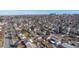 Wide aerial view of the neighborhood with tree-lined streets, diverse home styles, and city skyline in the distance at 705 Kenton St, Aurora, CO 80010