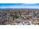 Expansive aerial view of a residential area with houses nestled among trees and the mountains visible in the background at 705 Kenton St, Aurora, CO 80010