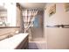 Bathroom showcasing sleek vanity, tiled walls, and a shower-tub combination at 705 Kenton St, Aurora, CO 80010