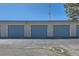 Three blue garage doors in a gray building, each with a standard gray door at 108 W Byers Pl # G1, Denver, CO 80223