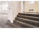 Inviting carpeted staircase leading to the upper levels with natural light and neutral colors at 108 W Byers Pl # G1, Denver, CO 80223