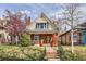 Charming brick home with a peaked roof, well-maintained lawn, and mature landscaping at 130 S Corona St, Denver, CO 80209
