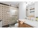 Stylish bathroom boasts a glass shower with decorative tile and modern gold fixtures at 18045 Arrowwood Dr, Monument, CO 80132