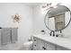 Clean bathroom with marble countertop, round mirror, stylish fixtures, and neutral tones at 18045 Arrowwood Dr, Monument, CO 80132