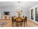 Dining area with chandelier, wood table, stylish chairs, and access to deck through glass doors at 18045 Arrowwood Dr, Monument, CO 80132