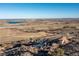 An aerial view of the home and surrounding land including a lake and sprawling terrain at 11683 Pointe View Dr, Longmont, CO 80503