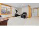Carpeted basement area featuring an exercise machine, cozy armchair and natural light at 11683 Pointe View Dr, Longmont, CO 80503