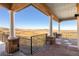 Covered patio featuring stone columns and iron railing with sweeping views of the landscape at 11683 Pointe View Dr, Longmont, CO 80503
