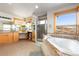 Bathroom featuring a soaking tub, walk-in shower, and dual sinks, complemented by mountain views at 11683 Pointe View Dr, Longmont, CO 80503