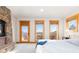 Well-lit main bedroom with a stone fireplace and three windows with an outdoor view at 11683 Pointe View Dr, Longmont, CO 80503