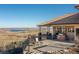 Outdoor patio with stone columns and outdoor kitchen with seating overlooking the landscape at 11683 Pointe View Dr, Longmont, CO 80503