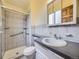 Bathroom featuring a shower with grab bars, a grey vanity, and grey tile at 2893 S Joslin Ct, Denver, CO 80227