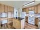 Traditional kitchen featuring wood cabinets, an island with a black countertop, and white appliances at 2893 S Joslin Ct, Denver, CO 80227