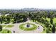 Aerial view of a roundabout surrounded by a park and trees, with the city skyline in the distance at 1519 E 29Th Ave, Denver, CO 80205