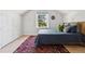 Bright bedroom features a large window, a cozy bed, and light wood floors with an interesting area rug at 1519 E 29Th Ave, Denver, CO 80205