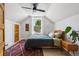 Bright bedroom with a cozy bed, wood floors, white walls, ceiling fan and natural light from the large window at 1519 E 29Th Ave, Denver, CO 80205
