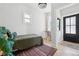 Compact bedroom with a single bed, a small desk by the window, and a striking black paneled door at 1519 E 29Th Ave, Denver, CO 80205